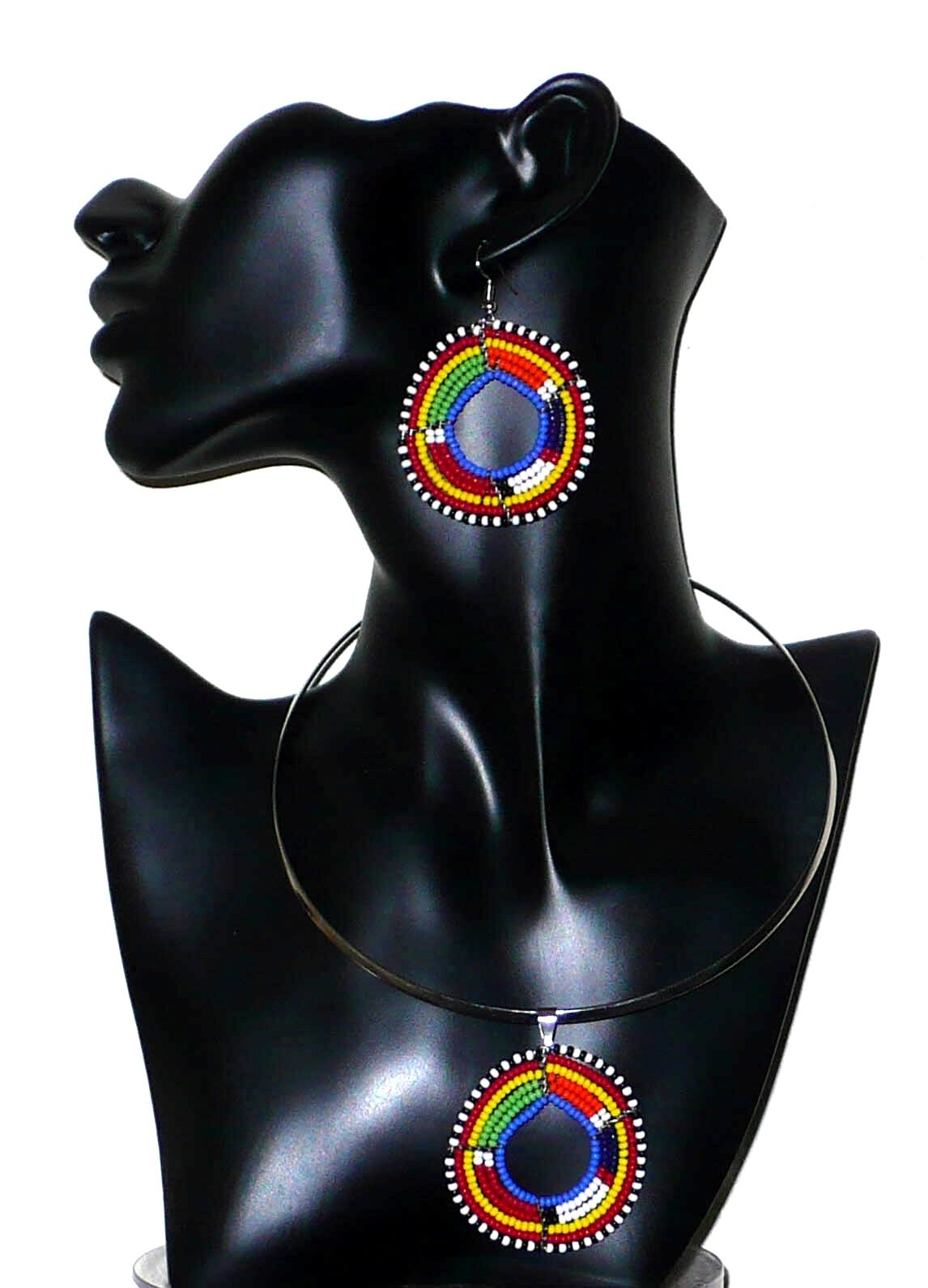 Parure de bijoux africains à motifs et couleurs ethniques Massai comprenant un collier ras-de-cou avec médaillon, et une paire de boucles d'oreilles rondes assorties. Parure présentées sur un mannequin. Timeless Fineries