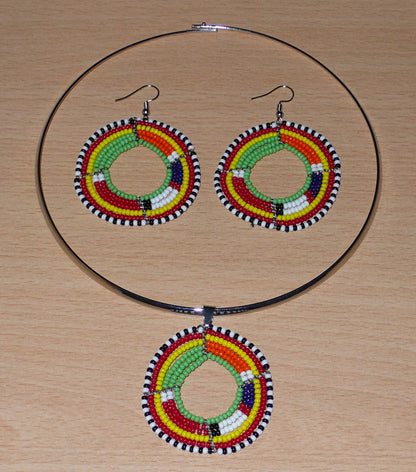 Bijoux africains. Parure contemporaine de bijoux africains Massai se composant d'un collier ras-de-cou en laiton orné d'un médaillon aux couleurs et motifs Massai fait de perles de rocaille vertes et multicolores montées en forme de cercles, ainsi que d'une paire de boucles d'oreilles rondes assorties au collier. Timeless Fineries